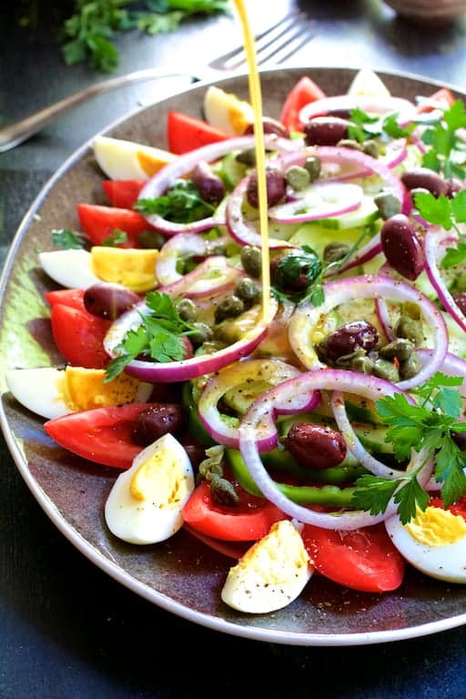 Photo of dressing being drizzled over salad.