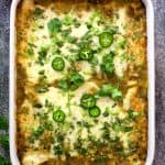 Lima Bean and Potato Enchiladas with Hatch Green Chile Sauce in white rectangular baking dish.