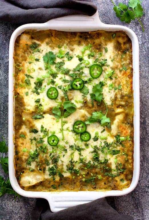 Lima Bean and Potato Enchiladas with Hatch Green Chile Sauce in white rectangular baking dish.