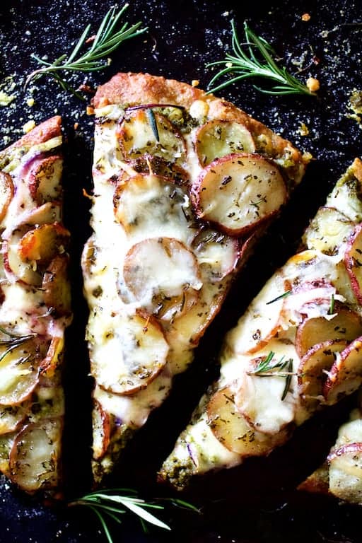 Close-up photo of a slice of Naan Potato Pizza with Radish Pesto and Smoked Mozzarella.
