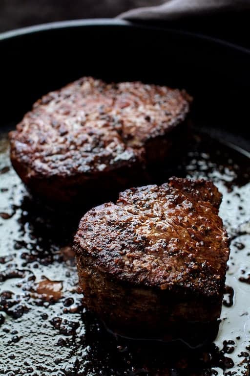 Photo of two seared fillets in cast iron skillet.