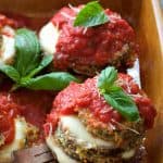 Eggplant Parmesan Stacks in earthenware baking dish being lifted out with fork.