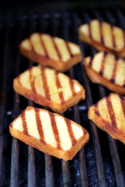 Photo of grilled pound cake slices on grill.