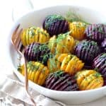 Roasted Hasselback Beets with Dill Dressing in white dish garnished with fresh dill sprigs.