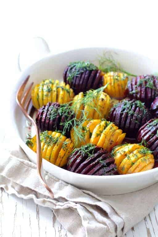 Roasted Hasselback Beets with Dill Dressing in white dish garnished with fresh dill sprigs.