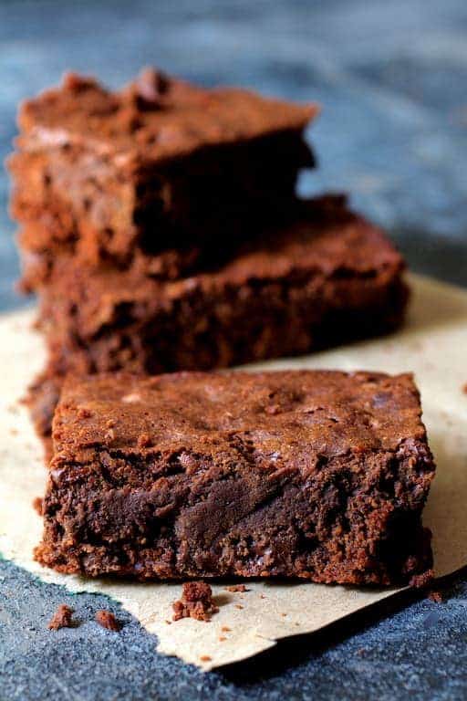 Three Whole Wheat Ancho Chili Brownies on a square of brown paper.