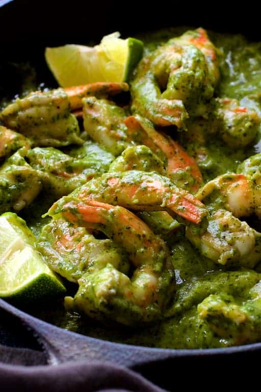 Close-up photo of Shrimp in Avocado Butter garnished with lime wedges.