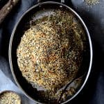 Everything Bagel Spice Whole Roasted Cauliflower in oval stainless steel roasting pan.