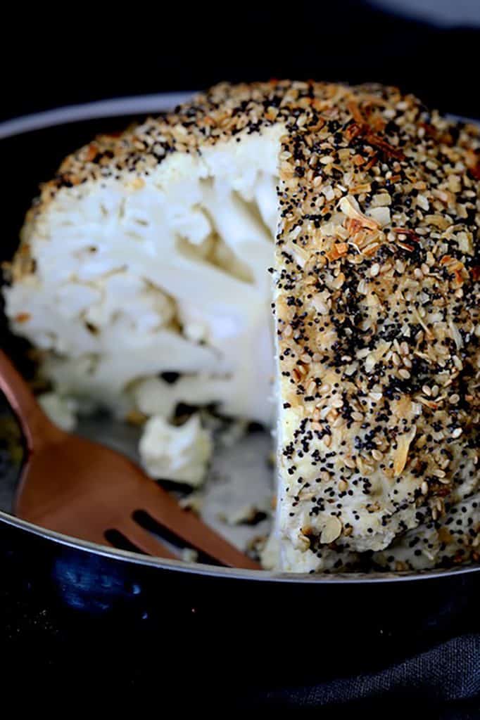 Close-up photo of Everything Bagel Spice Whole Roasted Cauliflower with a wedge removed to expose the interior.