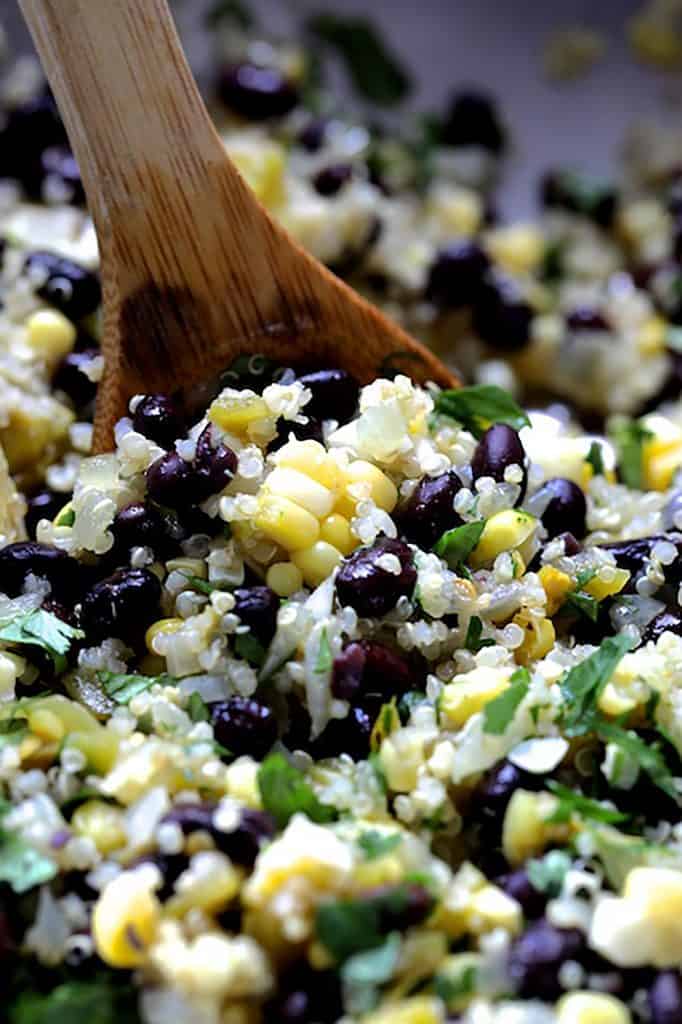 Photo of the filling of corn, black beans and rice being stirred with wooden spoon.
