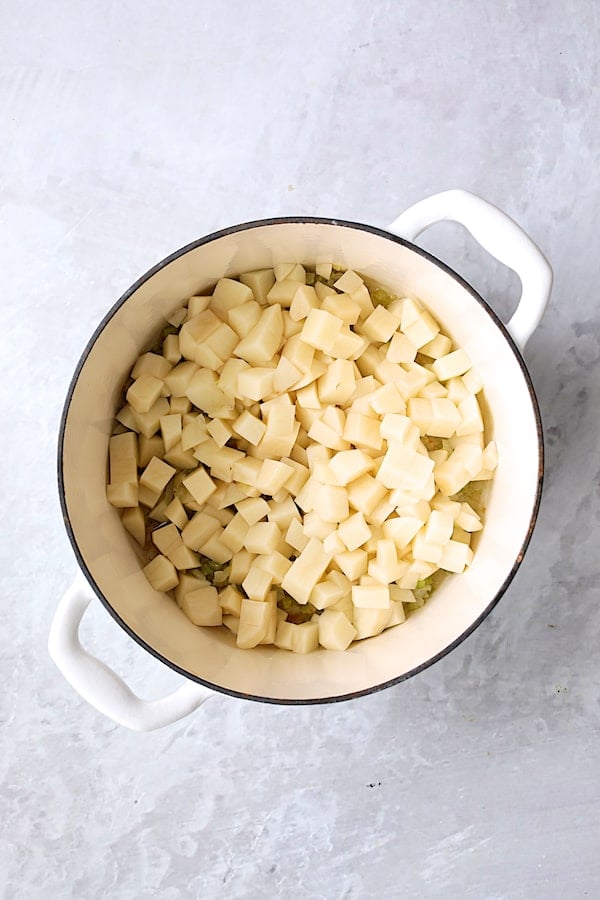 Photo of diced potatoes in white Dutch oven.