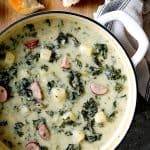 Creamy Potato Kielbasa and Kale Soup white enamel Dutch oven.