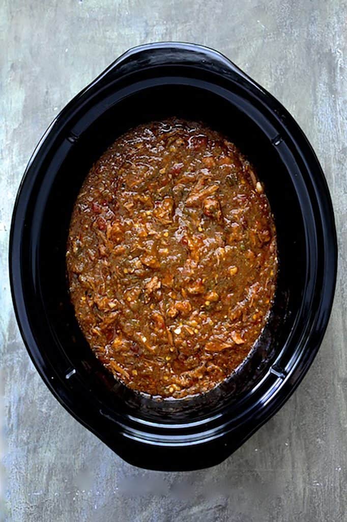 Photo of chili in slow cooker on gray background.