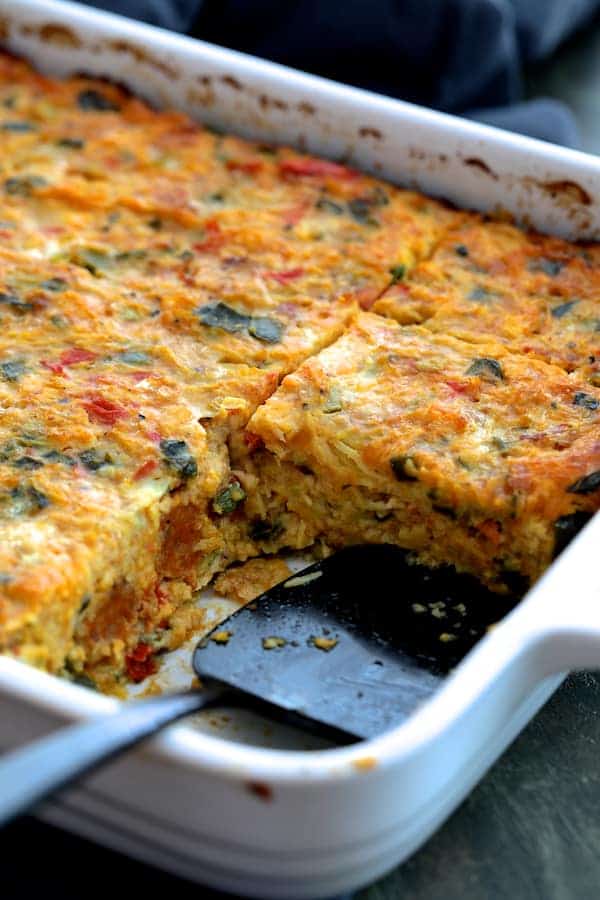 Photo of Spaghetti Squash Poblano and Chorizo Breakfast Casserole in white baking dish with pieces removed.