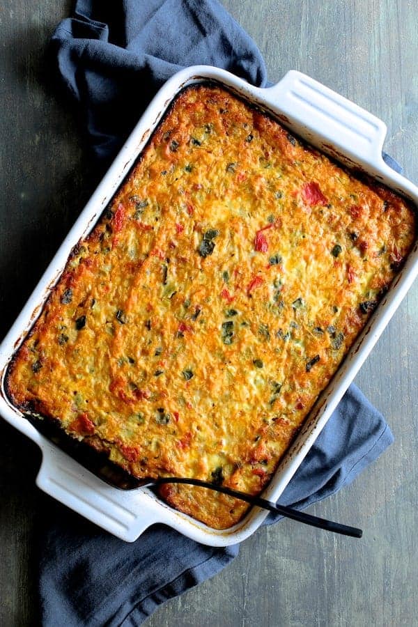 Photo of Spaghetti Squash Poblano Chorizo Breakfast Casserole in white baking dish on blue kitchen towel.