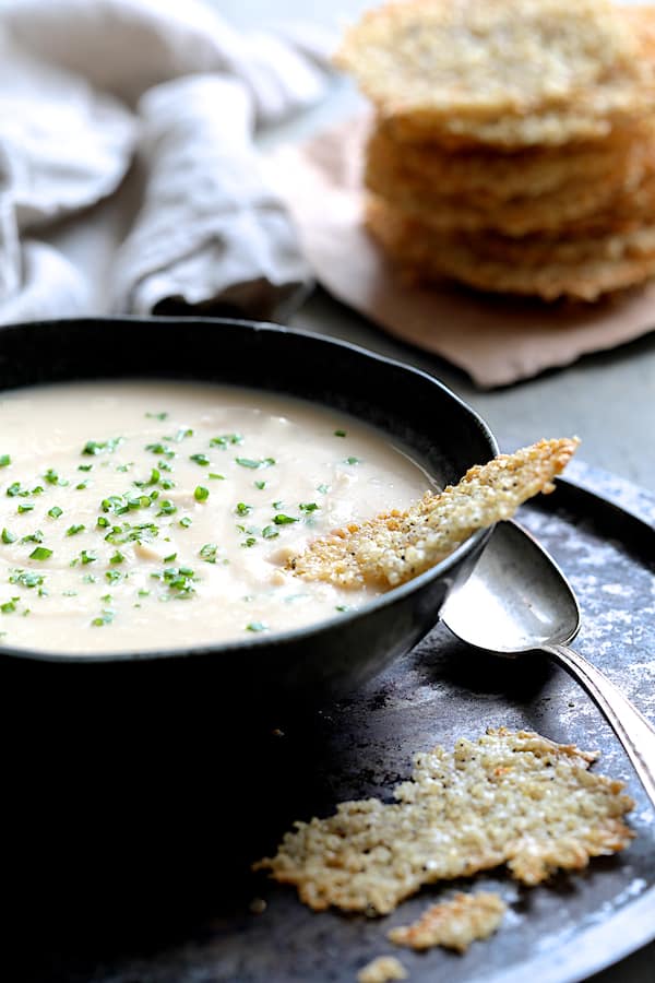 Photo of Creamy White Bean Rutabaga and Roasted Garlic Soup in black bowl.