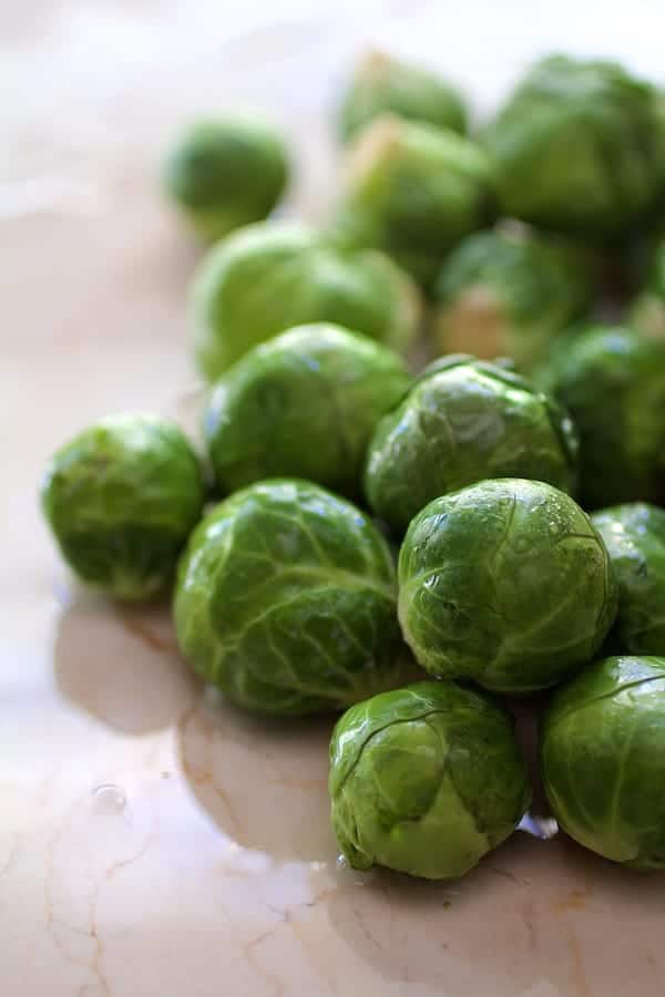 Photo of fresh Brussels sprouts on marble surface.