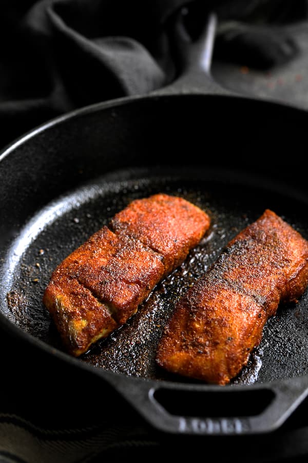 Photo of sea bass in cast iron skillet after being seared.