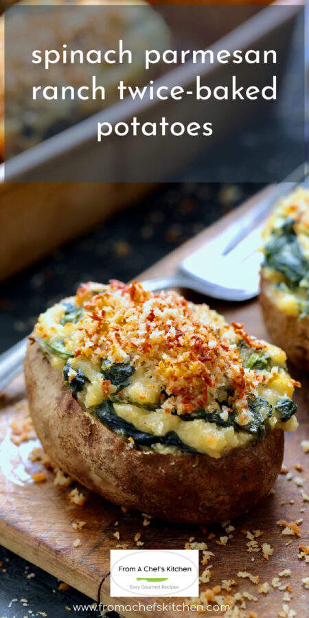 Spinach Parmesan Ranch Twice-Baked Potatoes on wood surface with serving fork.