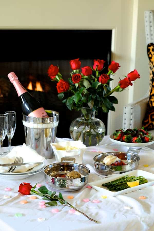 Photo of romantic dinner with roses by the fireplace.