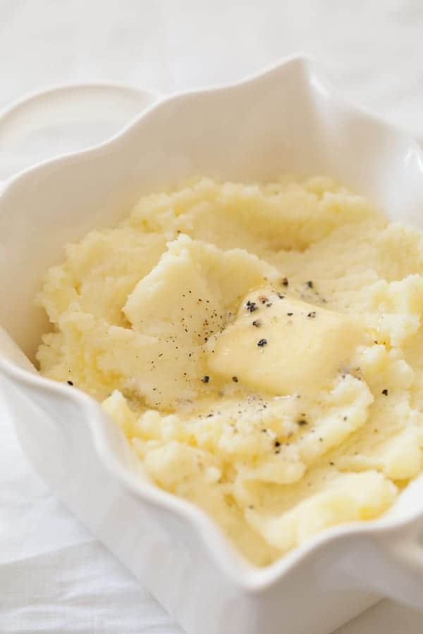 Photo of whipped Yukon gold potatoes with pat of butter melting into them.
