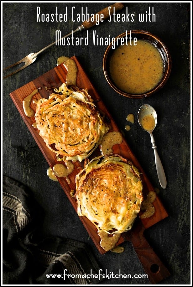 Pinterest graphic for Roasted Cabbage Steaks with Mustard Vinaigrette showing them on a cutting board drizzled with vinaigrette.