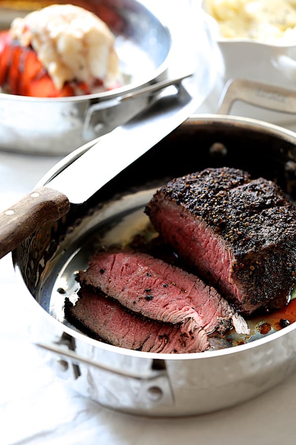 Photo of finished steak in roasting pan with some sliced.