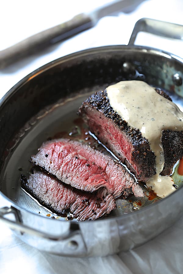Photo of finished filet in roasting pan drizzled with sauce.