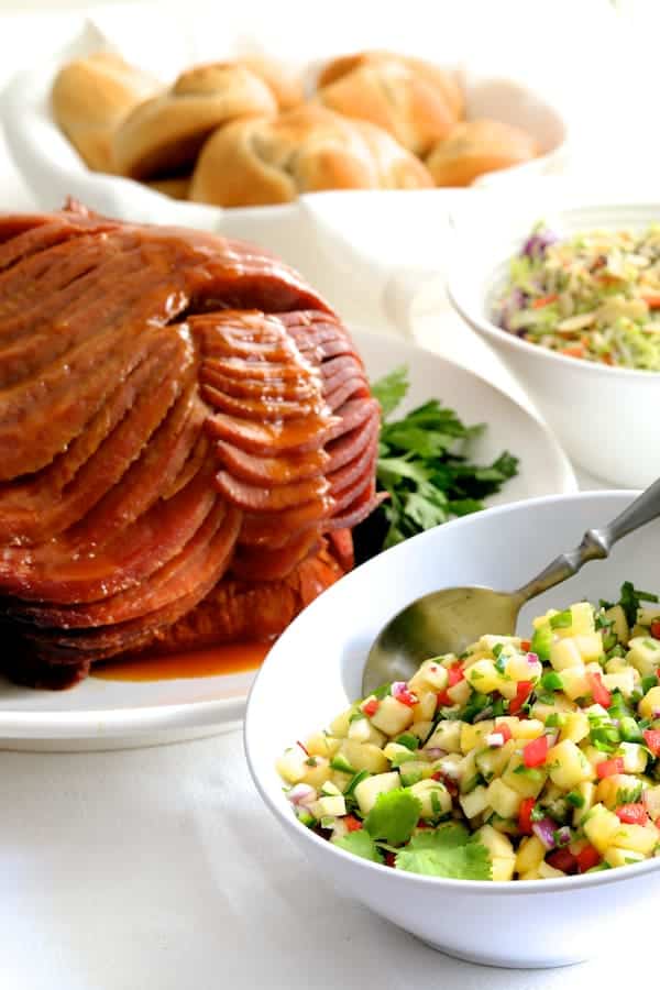 Photo of Slow Cooker Honey Ham with Pineapple Salsa along with some other side dishes.