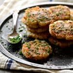 Parmesan Crusted Smashed Turnips - Stacked on metal tray and sprinkled with chives