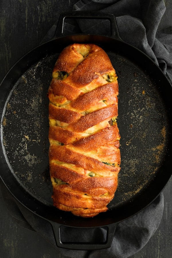 Photo of Savory Breakfast Strudel with Eggs, Sausage and Swiss Chard in cast iron pan with gray napkin.