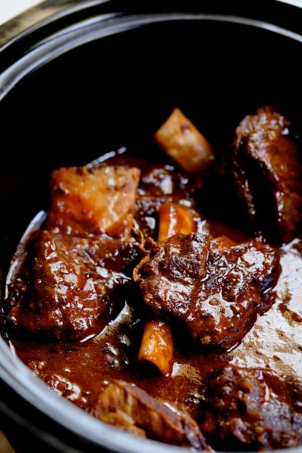 Photo of beef short ribs in a slow cooker.
