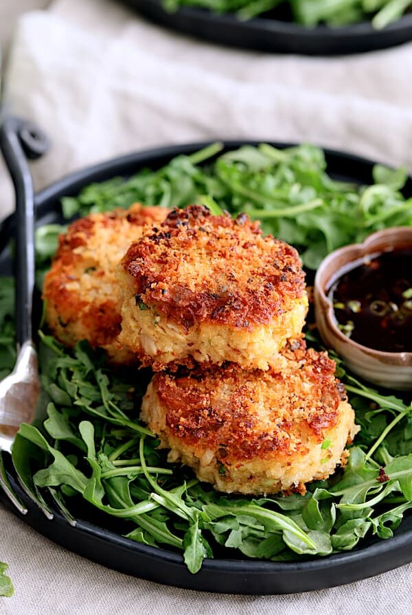 Tuna Kimchi Cakes with Soy Ginger Dipping Sauce - Close-up hero shot of cakes on plate with arugula and dipping sauce