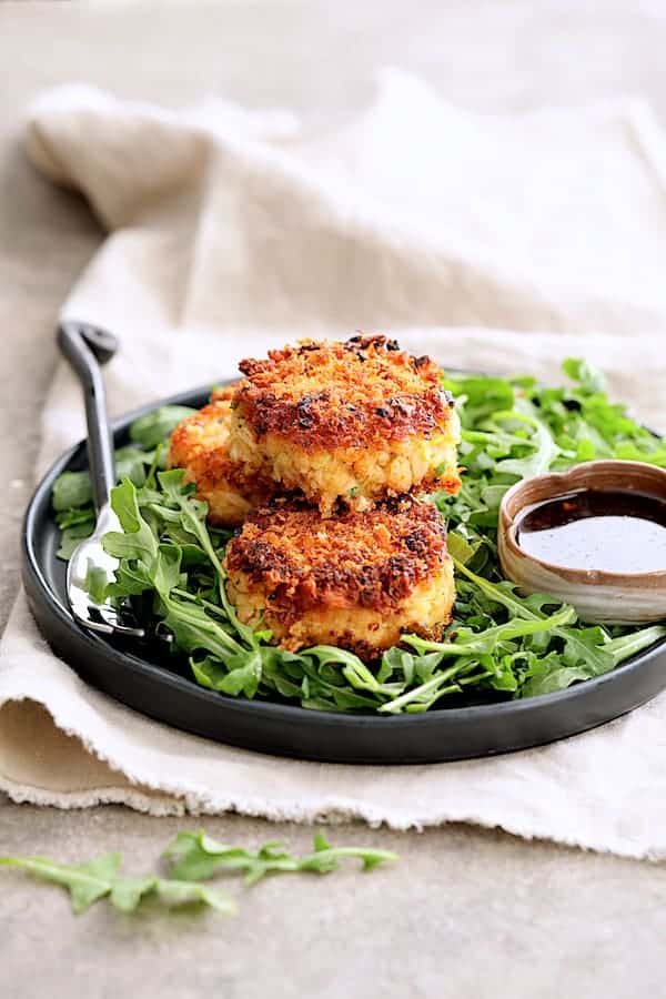 Tuna Kimchi Cakes with Soy Ginger Dipping Sauce - On plate over baby arugula