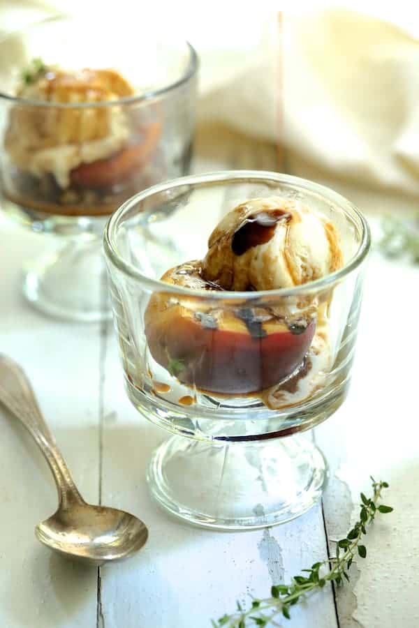 Photo of Grilled Peaches with Vanilla Ice Cream being drizzled with Honey - Balsamic Drizzle.
