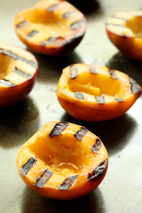 Photo of grilled peaches on sheet pan.