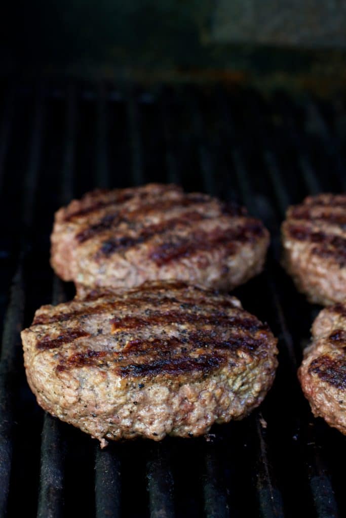Photo of four grilled beef burgers.