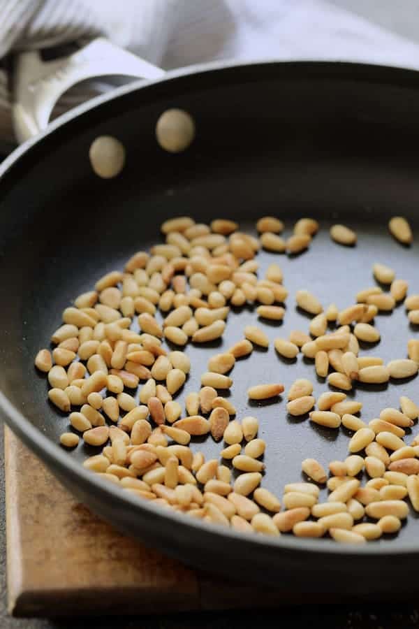 Photo of toasted pine nuts in nonstick skillet.