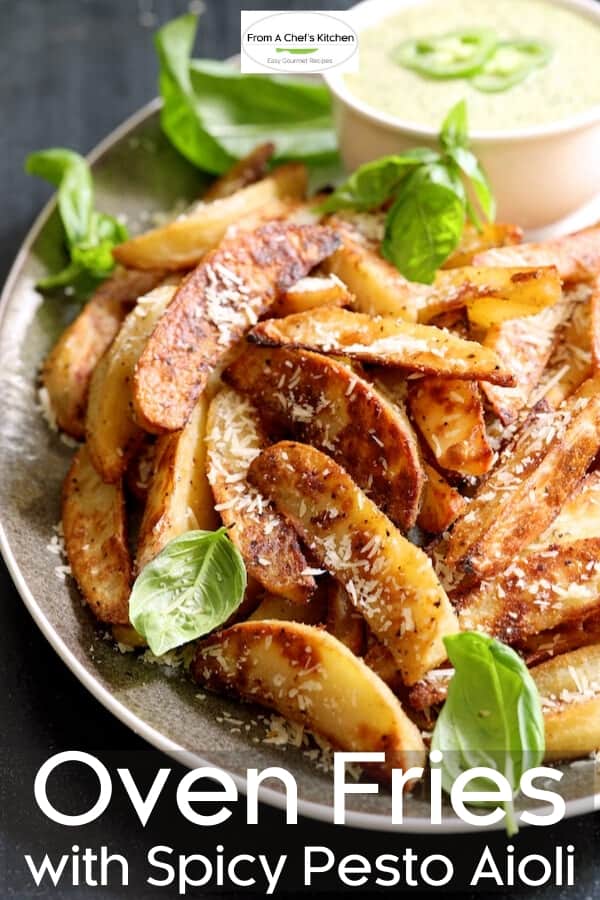 Pinterest graphic for Oven Fries with Spicy Pesto Aioli showing them on a gray-rimmed platter garnished with fresh basil leaves.
