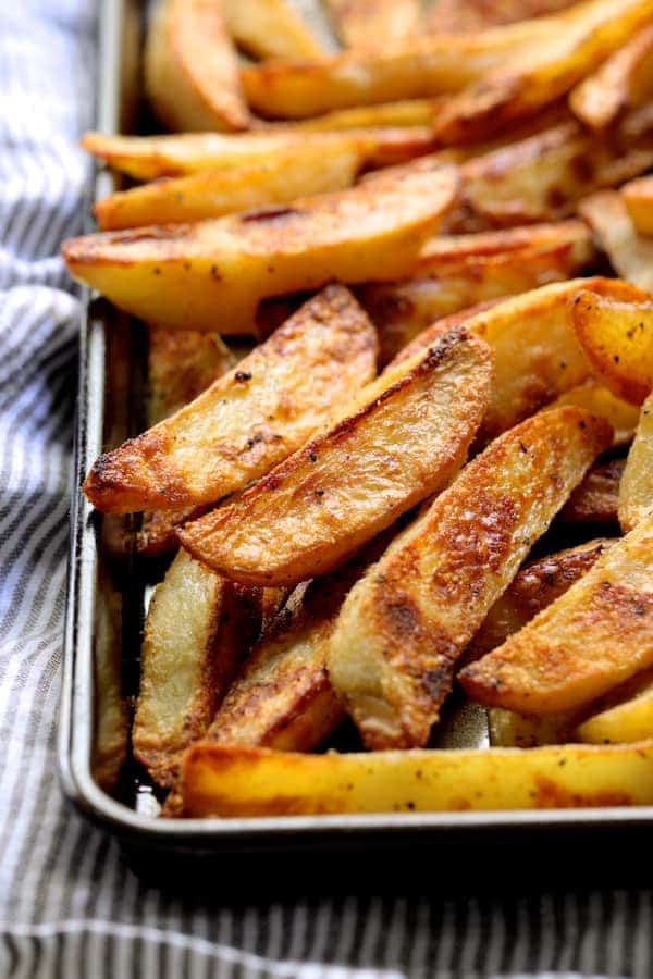 Close-up photo of cooked oven fries on baking sheet.