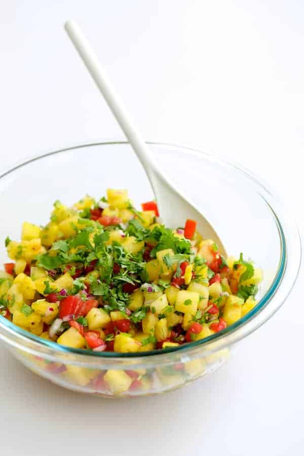 Photo of Watermelon Tomato Salsa in glass bowl with white spoon.