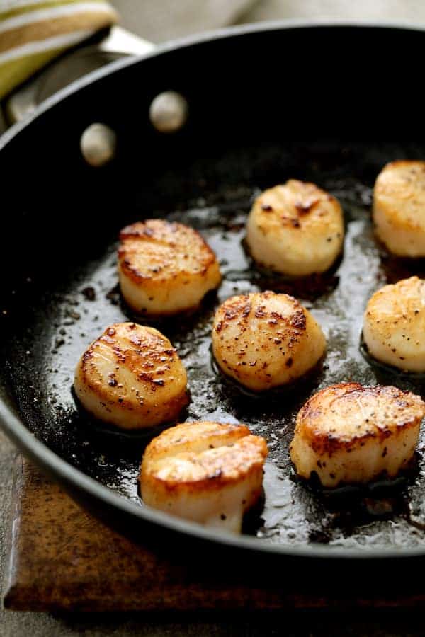 Photo of seared scallops in nonstick pan.