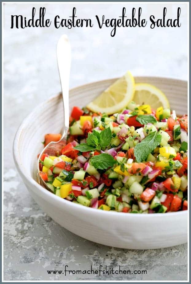 Pinterest graphic for Middle Eastern Vegetable Salad showing it in a white serving bowl garnished with fresh lemons and mint sprigs.