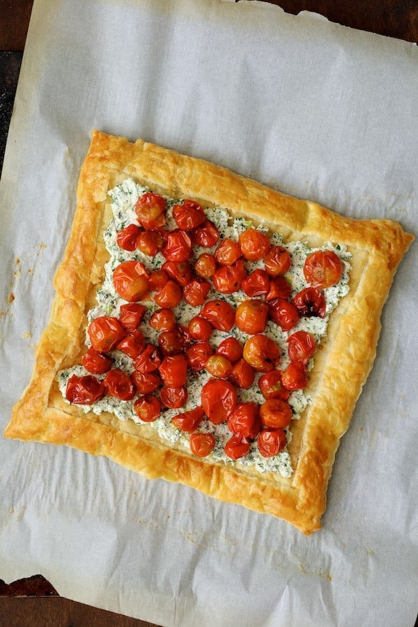 Photo of tart with cherry tomatoes on the ricotta mixture.