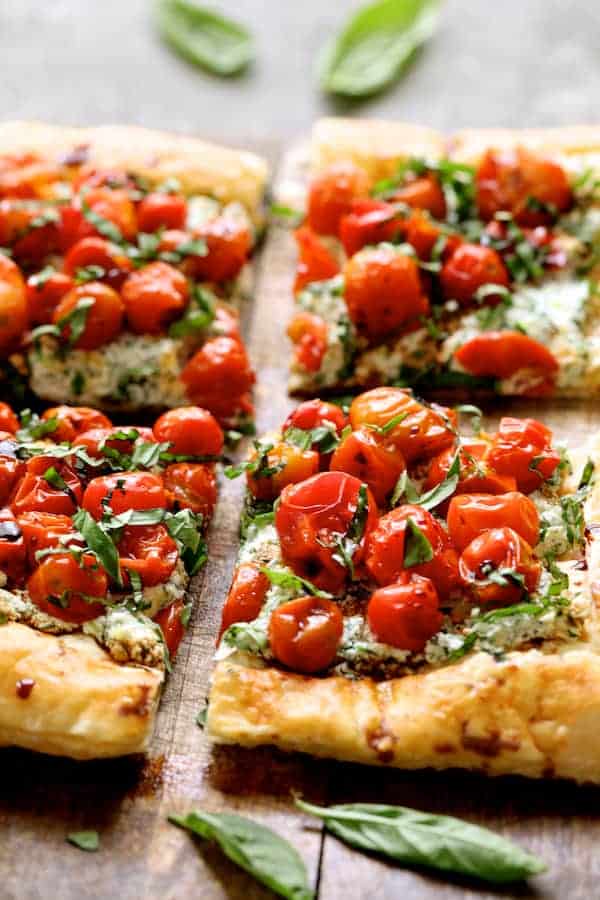 Close-up photo of Roasted Cherry Tomato Tart with Herbed Ricotta cut into four pieces.
