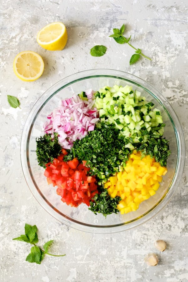 Photo of salad ingredients in glass mixing bowl before being stirred.