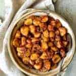 Chile Potatoes (Patatas Bravas Chilenas) in earthenware bowl with serving spoon.