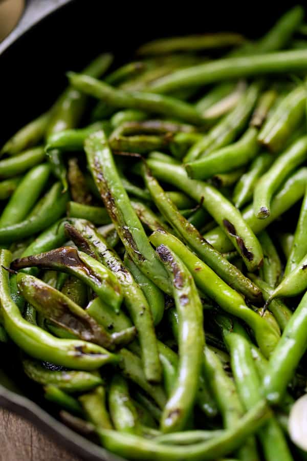 Close-up photo of Skillet Charred Green Beans with Goat Cheese Chipotle Butter in cast iron skillet.