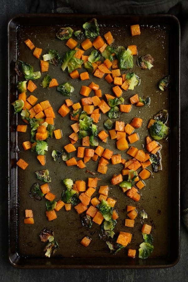 Photo of butternut squash and Brussels sprouts on baking sheet after being roasted.