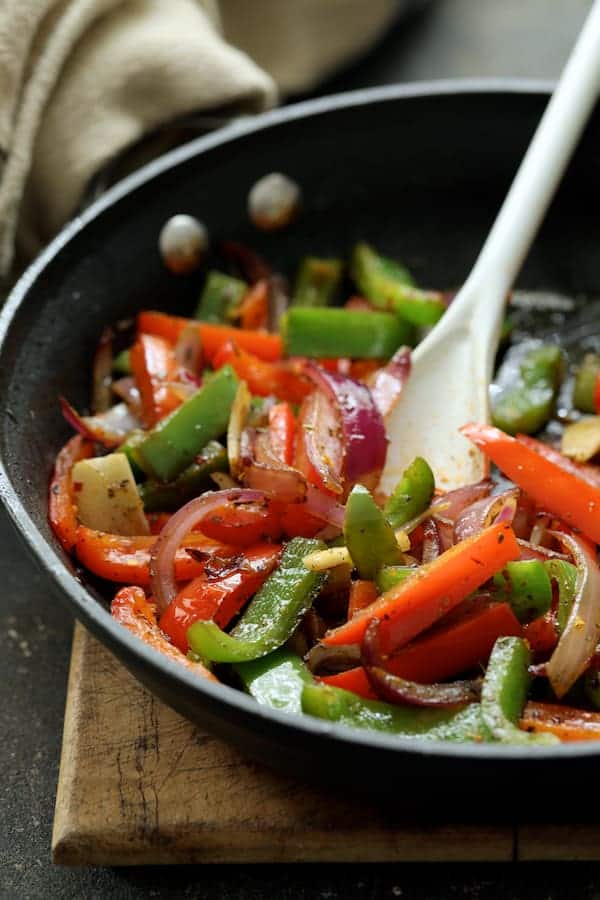 Photo of cooked onions and bell peppers in skillet.